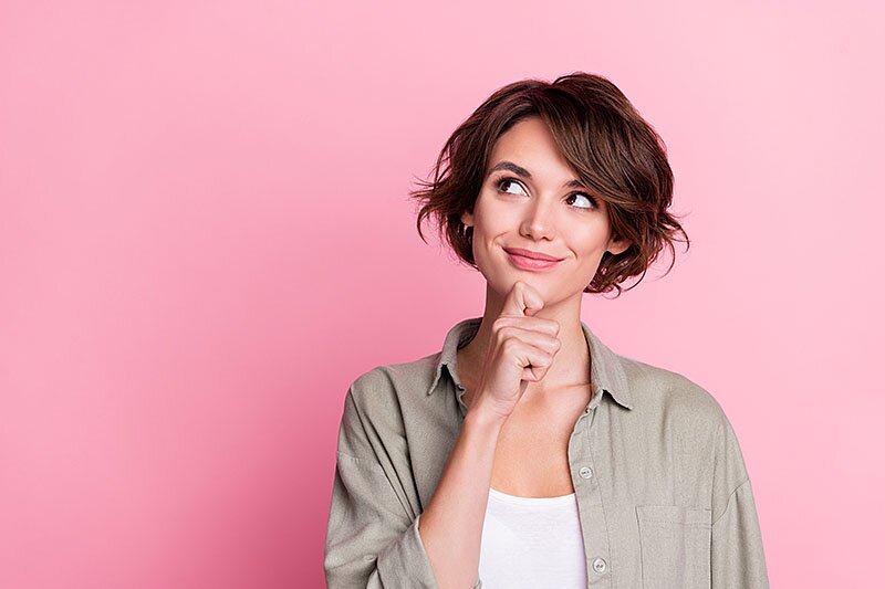 Frau in nachdenklicher Pose mit einer Hand am Kinn