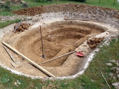 Ausgehobene Teichgrube. Schaufeln liegen noch im Sand.