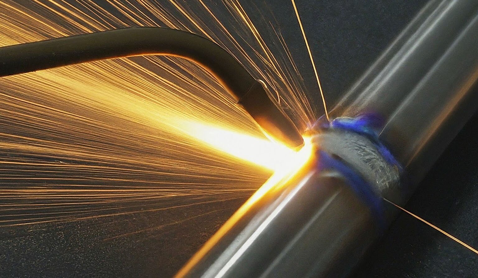 Zwei Metallrohre, die mit einem Schweißgerät verschweißt...