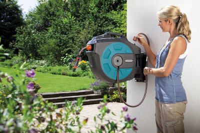 junge frau mit einer Gartenschlauchbox